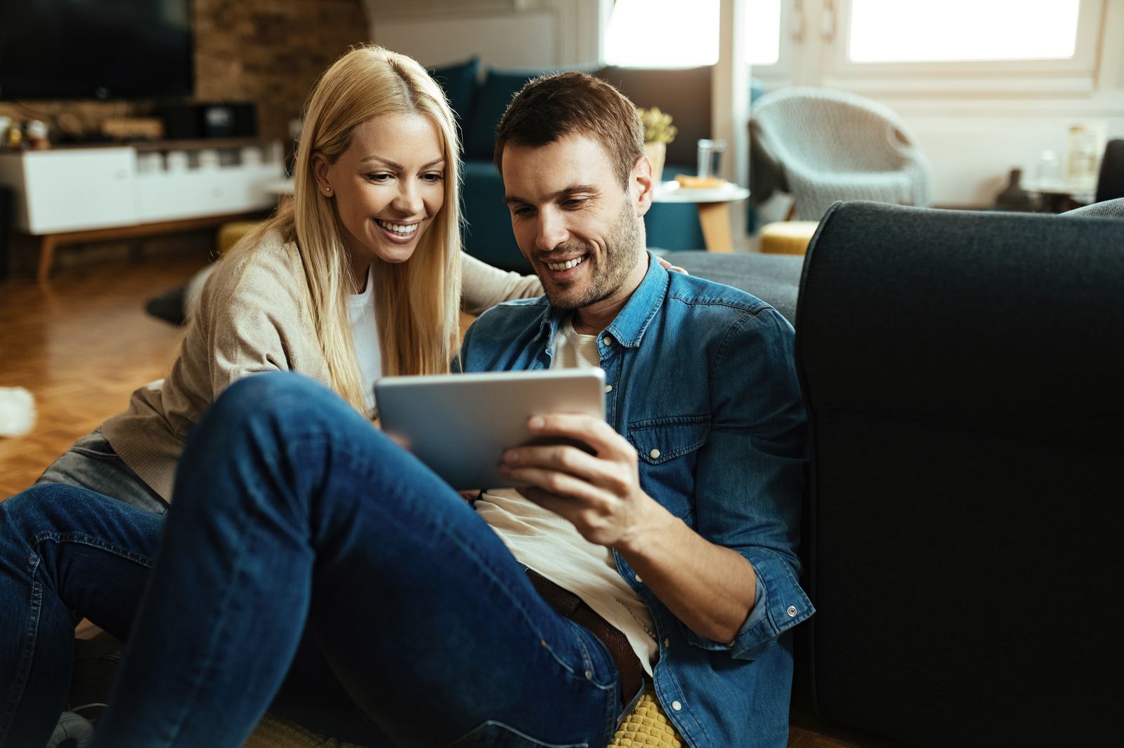 Couple relaxing at home browsing on a tablet connected to fast home internet